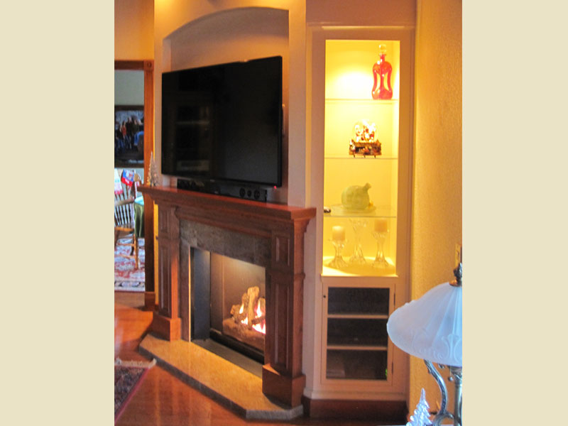 wood mantel with side display  cabinets . glass shelves , glass doors
granite hearth, recessed tv