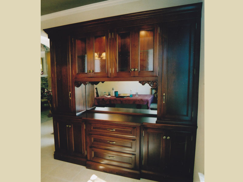 Mahogany wood wall unit 
With mirror backs ,carvings molded doors , crown.acetone finish