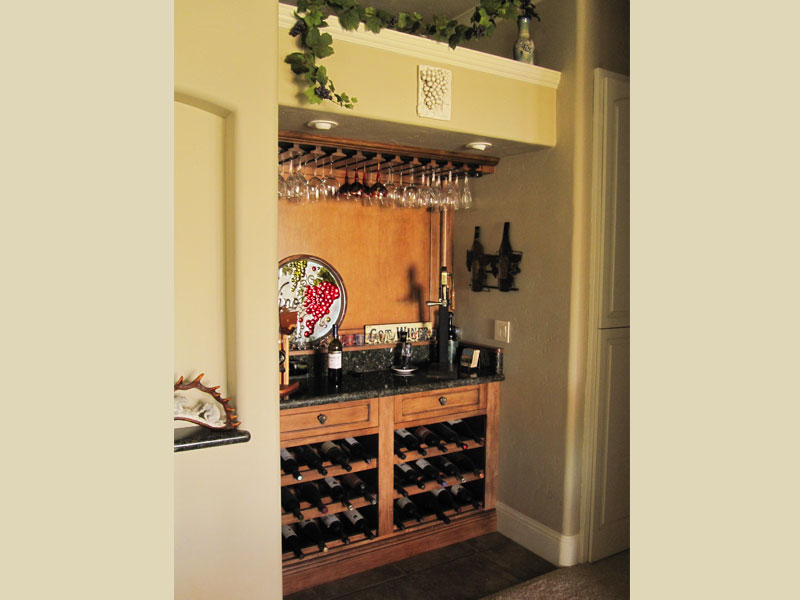 Paneled maple wood wine bar
Granite counter top with rack below . Stained to match