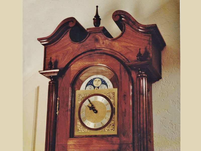 Walnut clock with full bonnet , fluted columns , finials at corners